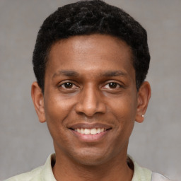 Joyful latino young-adult male with short  black hair and brown eyes