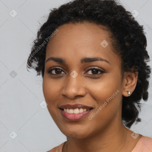 Joyful black young-adult female with long  black hair and brown eyes