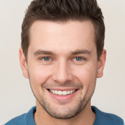 Joyful white young-adult male with short  brown hair and grey eyes