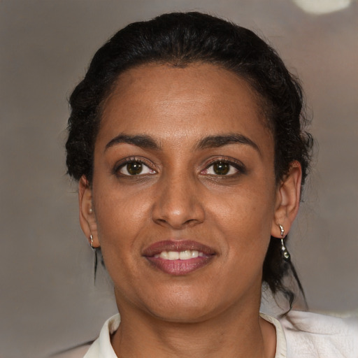 Joyful black young-adult female with medium  brown hair and brown eyes