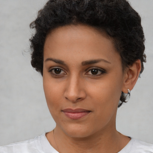 Joyful black young-adult female with short  brown hair and brown eyes