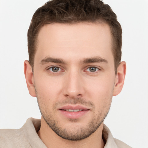 Joyful white young-adult male with short  brown hair and grey eyes