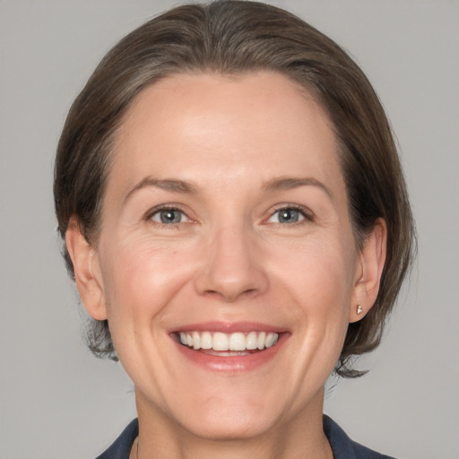 Joyful white adult female with medium  brown hair and grey eyes