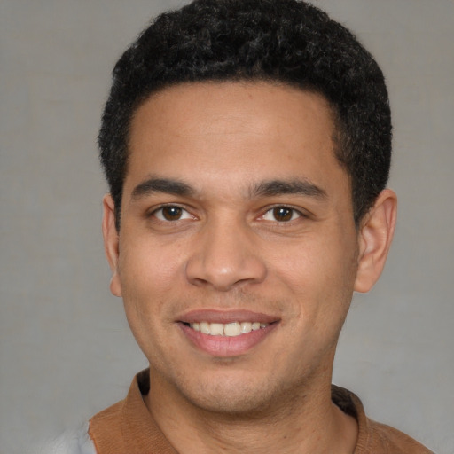 Joyful latino young-adult male with short  brown hair and brown eyes