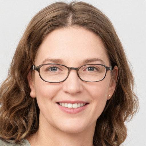 Joyful white adult female with medium  brown hair and green eyes