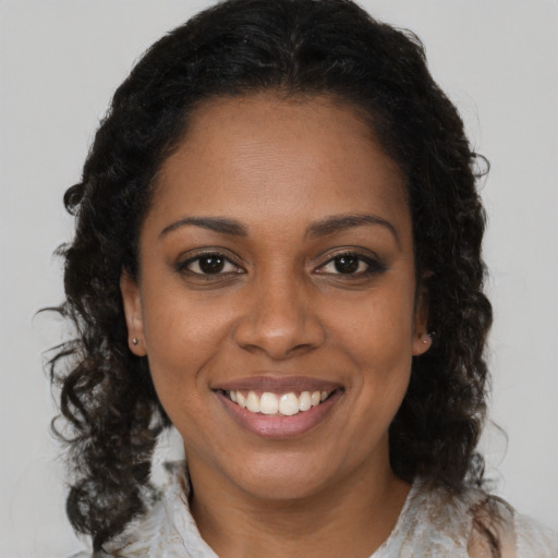 Joyful black young-adult female with medium  brown hair and brown eyes