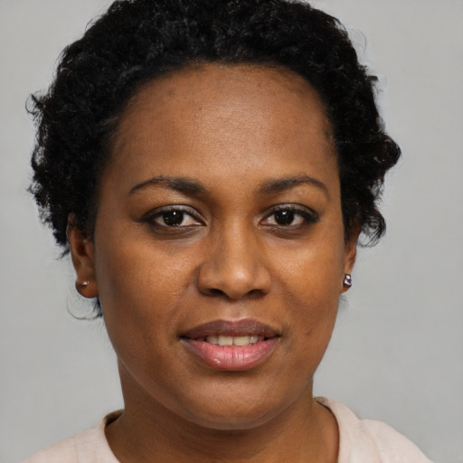 Joyful black young-adult female with short  brown hair and brown eyes
