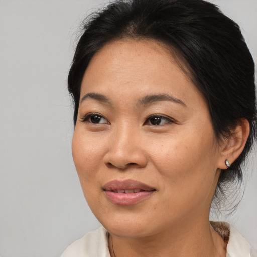 Joyful asian adult female with medium  brown hair and brown eyes