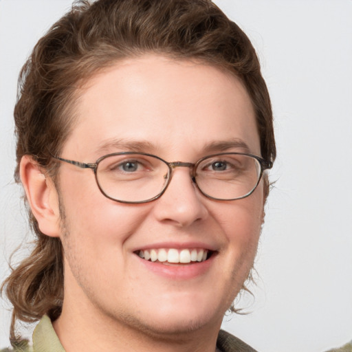 Joyful white young-adult male with medium  brown hair and green eyes