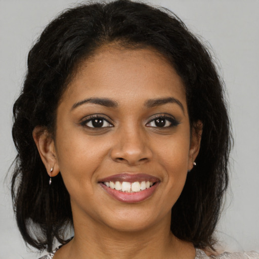 Joyful black young-adult female with medium  brown hair and brown eyes