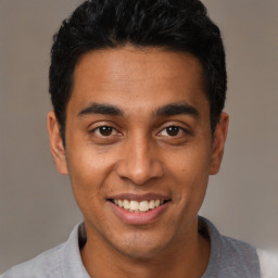 Joyful latino young-adult male with short  black hair and brown eyes