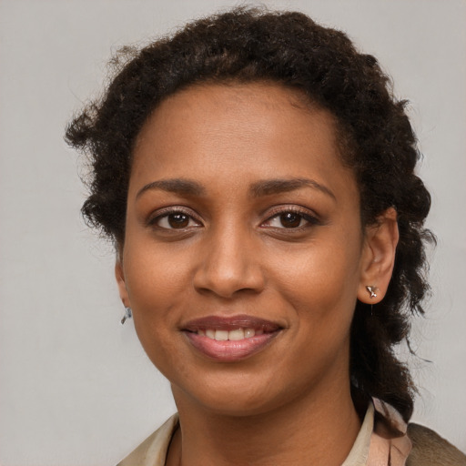 Joyful black young-adult female with short  brown hair and brown eyes