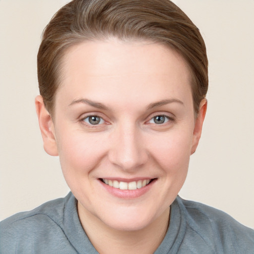 Joyful white young-adult female with short  brown hair and grey eyes