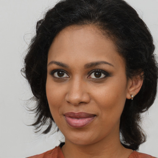 Joyful black young-adult female with medium  brown hair and brown eyes