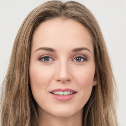 Joyful white young-adult female with long  brown hair and green eyes