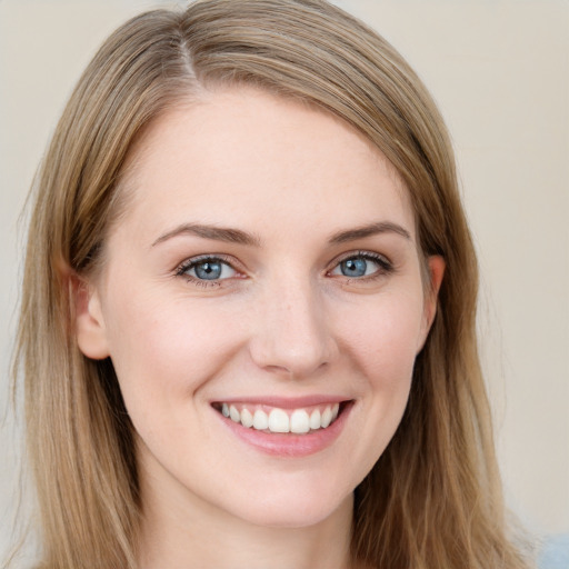 Joyful white young-adult female with long  brown hair and blue eyes