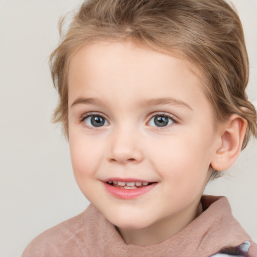 Joyful white child female with short  brown hair and blue eyes