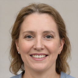 Joyful white adult female with medium  brown hair and grey eyes