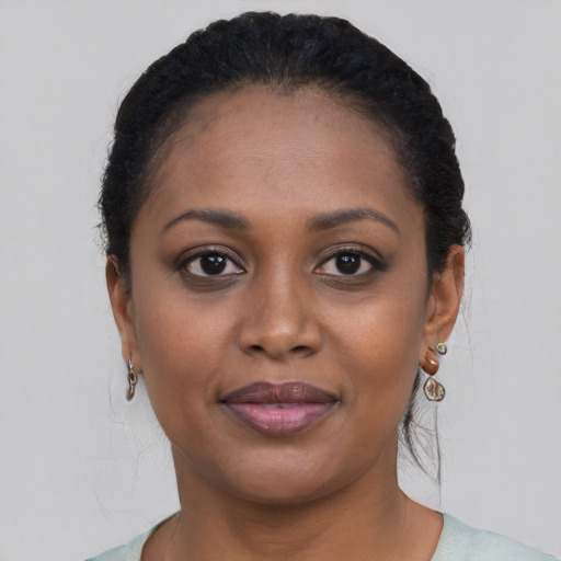 Joyful black young-adult female with short  black hair and brown eyes
