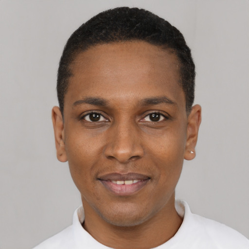 Joyful black young-adult male with short  black hair and brown eyes