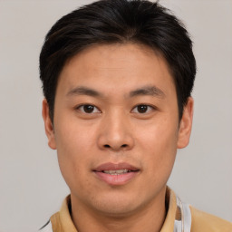 Joyful asian young-adult male with short  brown hair and brown eyes