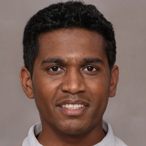 Joyful black young-adult male with short  black hair and brown eyes