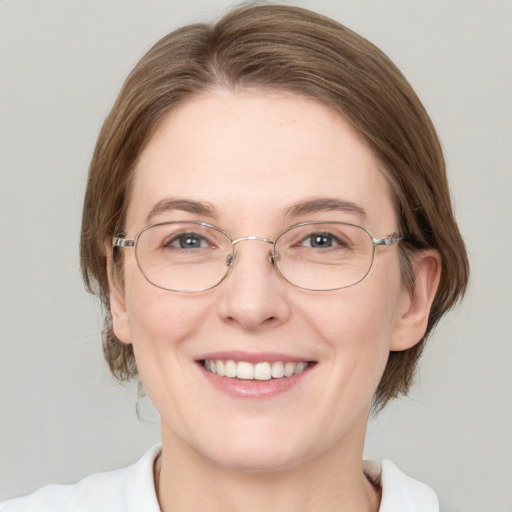 Joyful white adult female with medium  brown hair and green eyes