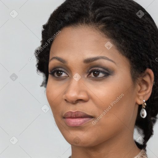 Joyful black young-adult female with long  brown hair and brown eyes