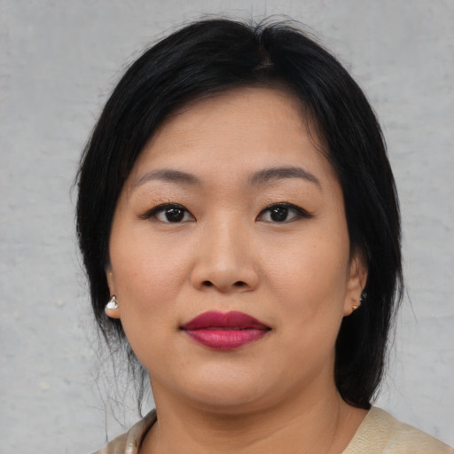 Joyful asian young-adult female with medium  black hair and brown eyes