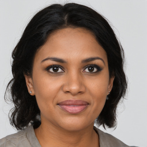 Joyful black young-adult female with long  brown hair and brown eyes