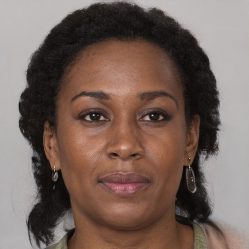 Joyful black adult female with long  brown hair and brown eyes