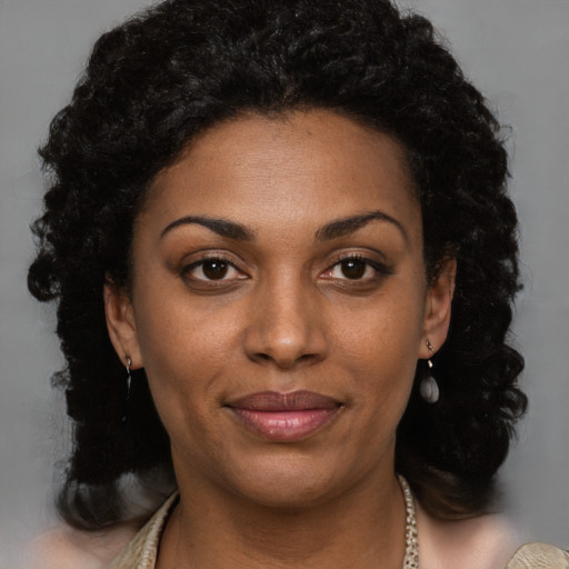 Joyful black young-adult female with long  brown hair and brown eyes
