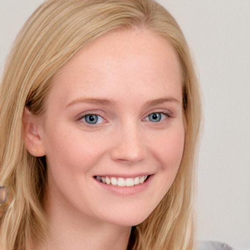 Joyful white young-adult female with long  blond hair and blue eyes