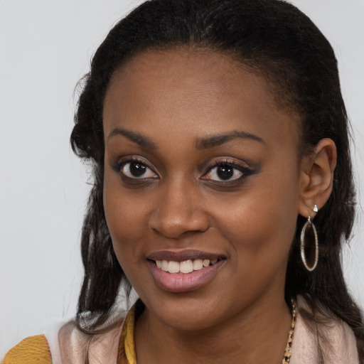 Joyful black young-adult female with long  brown hair and brown eyes