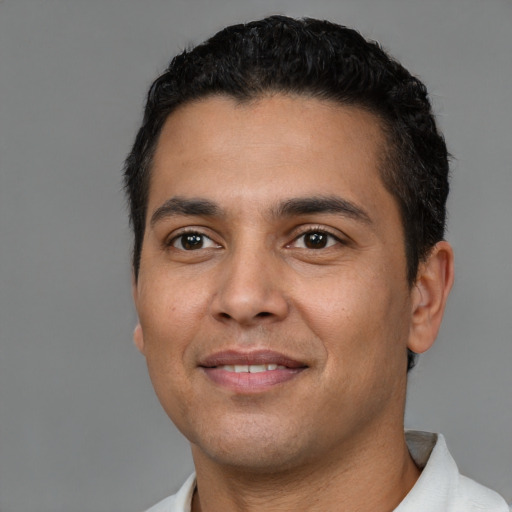 Joyful latino young-adult male with short  black hair and brown eyes