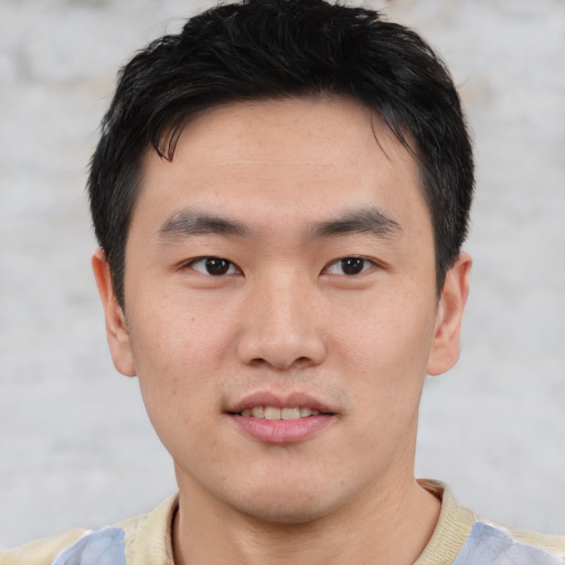 Joyful asian young-adult male with short  black hair and brown eyes