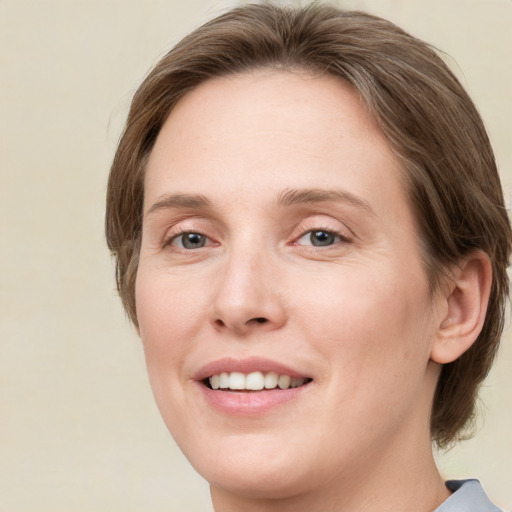 Joyful white young-adult female with medium  brown hair and green eyes