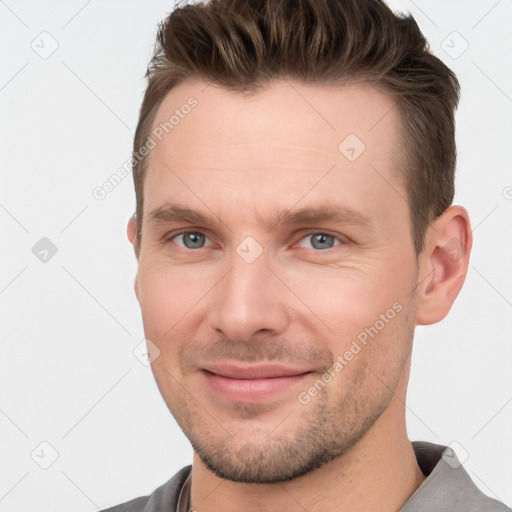 Joyful white young-adult male with short  brown hair and grey eyes