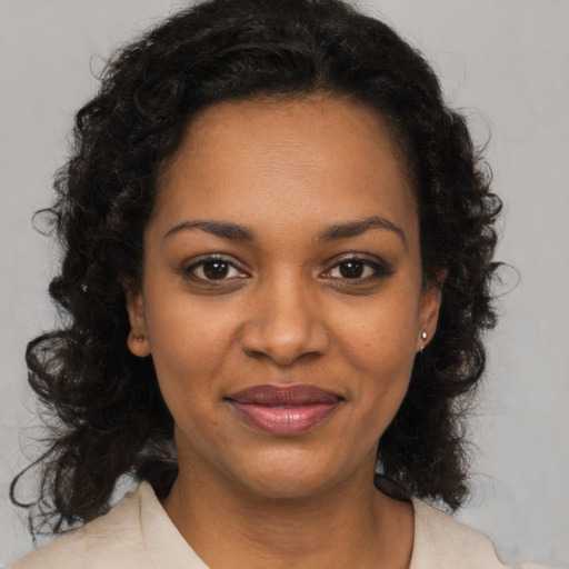 Joyful black young-adult female with medium  brown hair and brown eyes