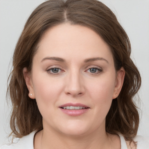 Joyful white young-adult female with medium  brown hair and grey eyes