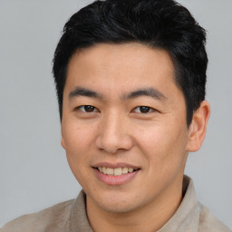 Joyful asian young-adult male with short  black hair and brown eyes