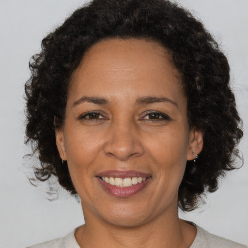 Joyful black adult female with short  brown hair and brown eyes