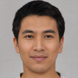 Joyful asian young-adult male with short  black hair and brown eyes