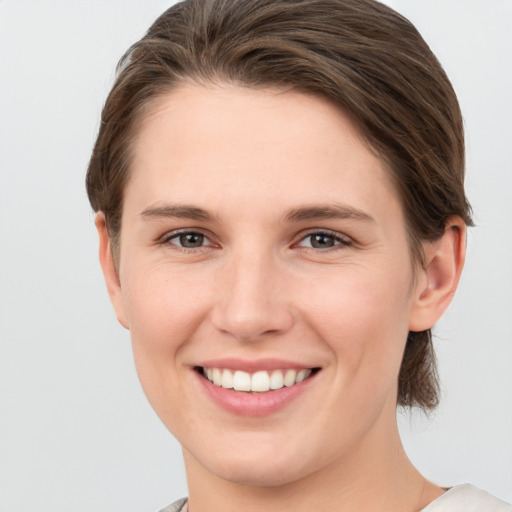 Joyful white young-adult female with short  brown hair and grey eyes