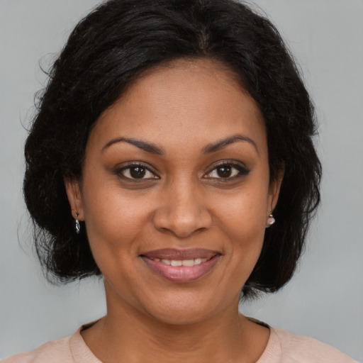 Joyful black adult female with medium  brown hair and brown eyes