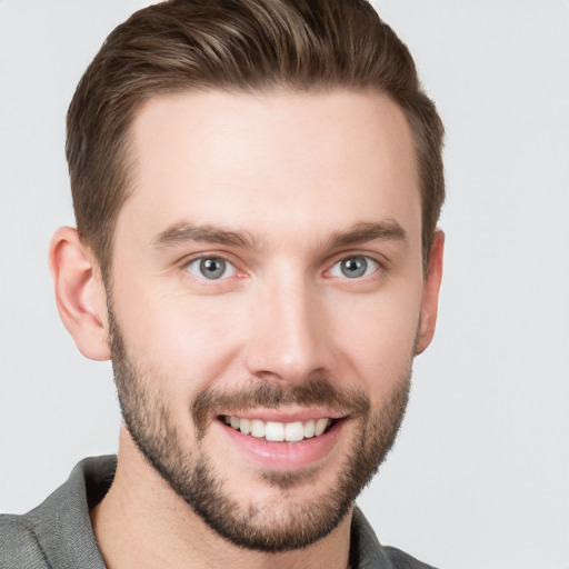 Joyful white young-adult male with short  brown hair and grey eyes