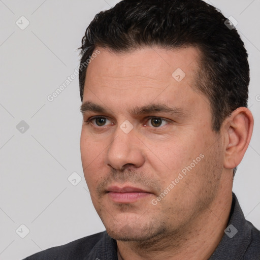 Joyful white adult male with short  black hair and brown eyes