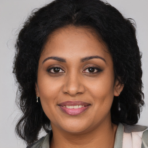 Joyful black young-adult female with long  brown hair and brown eyes