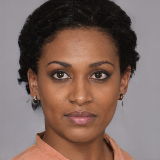 Joyful black young-adult female with short  brown hair and brown eyes