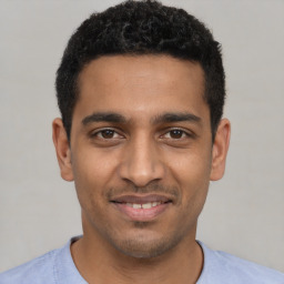 Joyful latino young-adult male with short  black hair and brown eyes